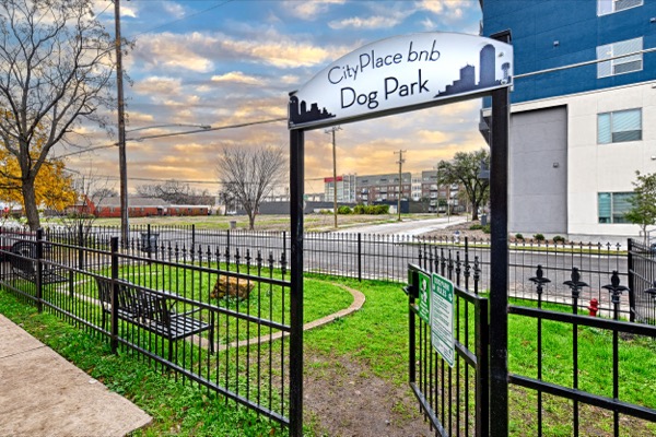 CityPlace bnb Dog Park sign over an iron gate with new construction behind