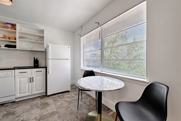 Small dining table with two chairs by a bright window