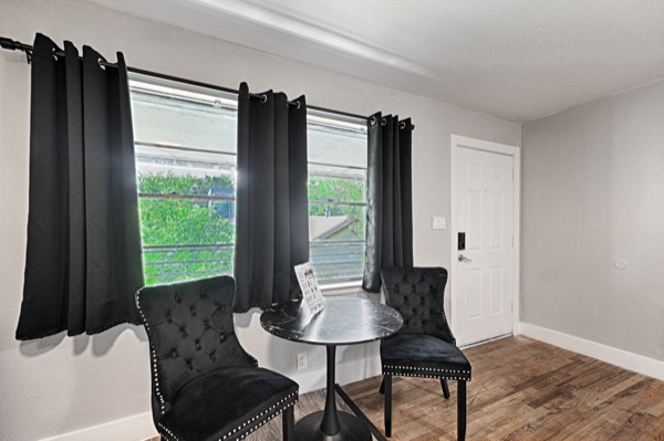 Refreshed unit sitting nook with black tufted chairs and round table by the window