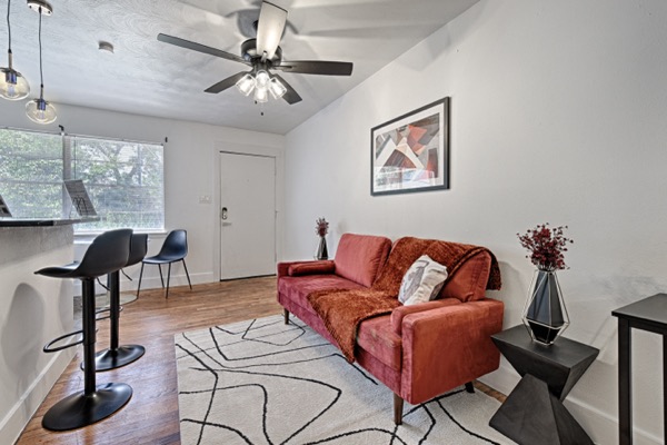 Open living area with sofa and breakfast bar into the kitchen