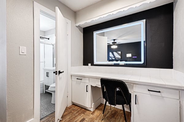 Refreshed unit vanity nook with backlit mirror on a black accent wall