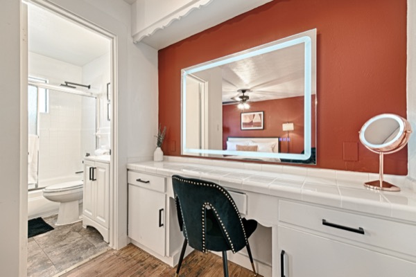 Vanity area with large lighted mirror and accent wall