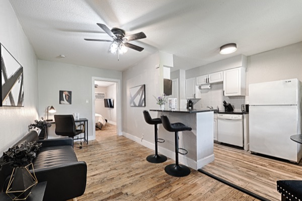 Refreshed unit kitchen with bar seating, open to the living area and bedroom beyond