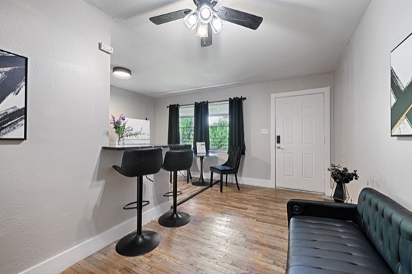 Refreshed unit dining nook with bar stools, round table and sofa beyond