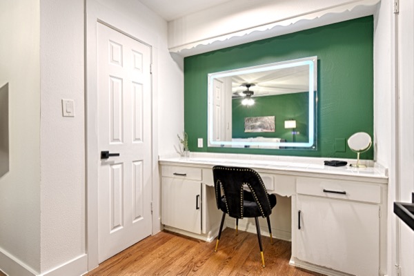 Suite 202 vanity nook with lighted mirror and green accent wall