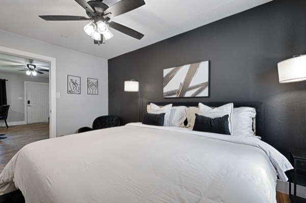 Refreshed unit bedroom with black accent wall, king bed, and modern finishes