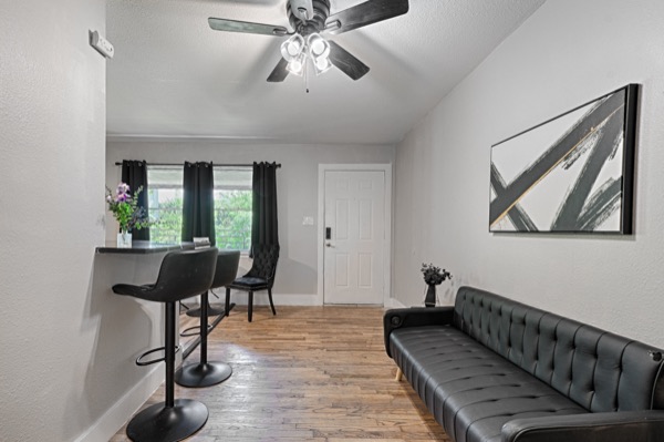 Refreshed unit living area with black leather sofa and bar seating