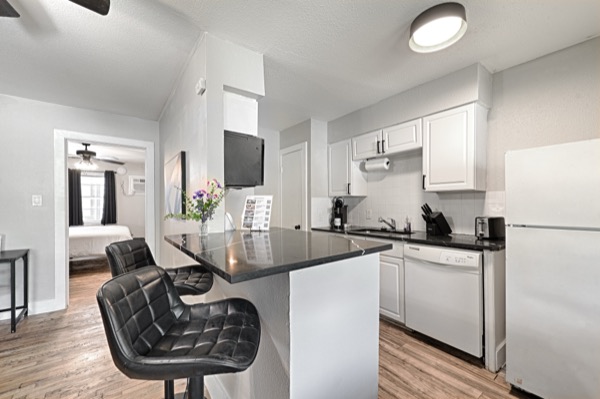 Refreshed unit white kitchen with island bar seating and full appliances